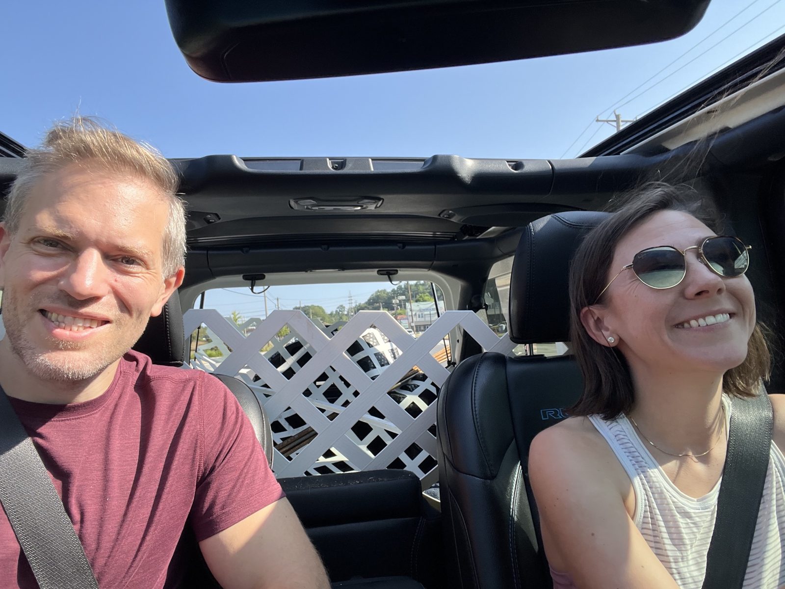Haley and Michael in a Jeep with the top off, white lattice and rebar packed in the back