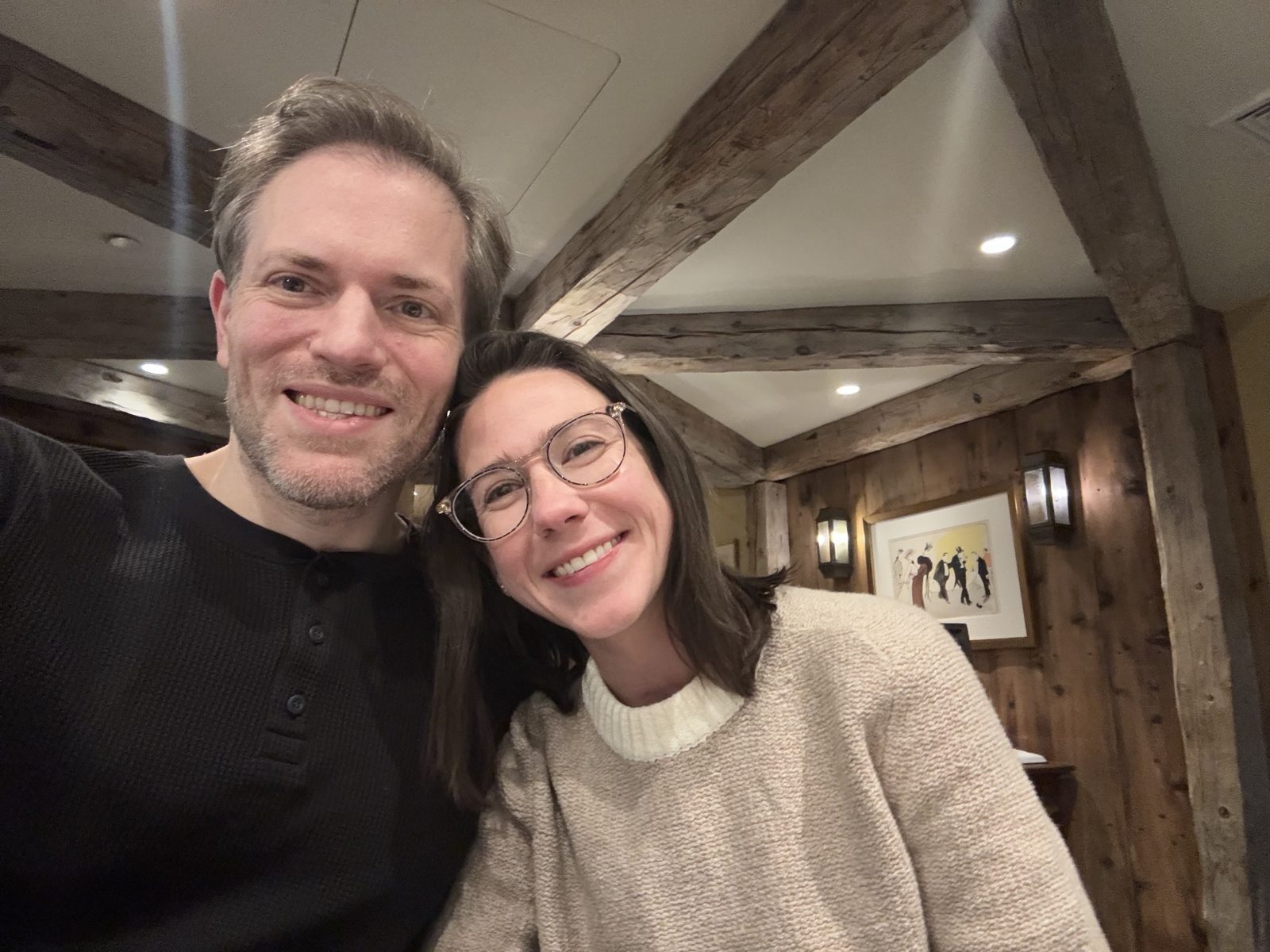 Haley and Michael smiling in a selfie in a restaurant with old wooden beams
