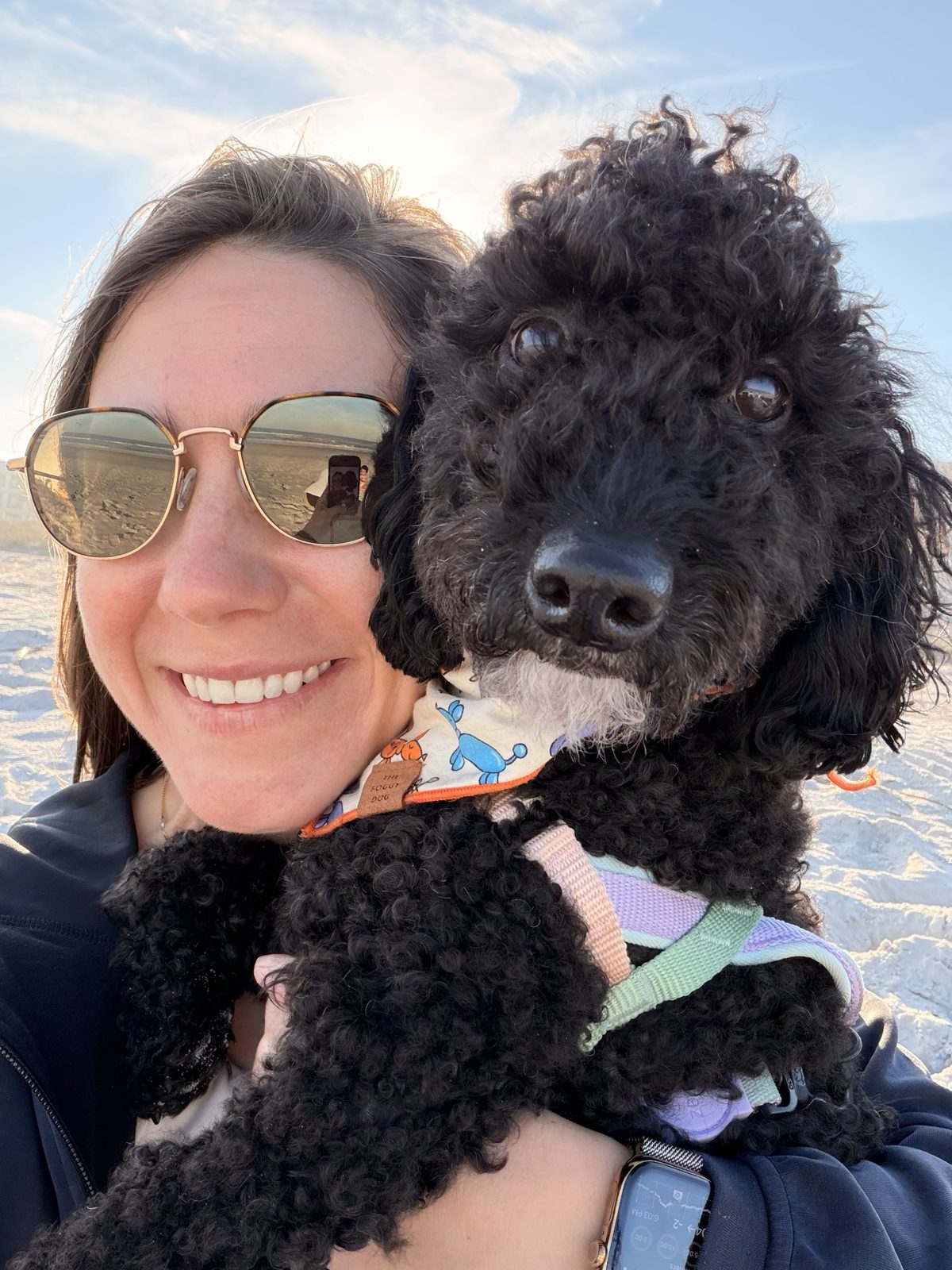 Haley in sunglasses smiling in a beach selfie with Wes on her shoulder