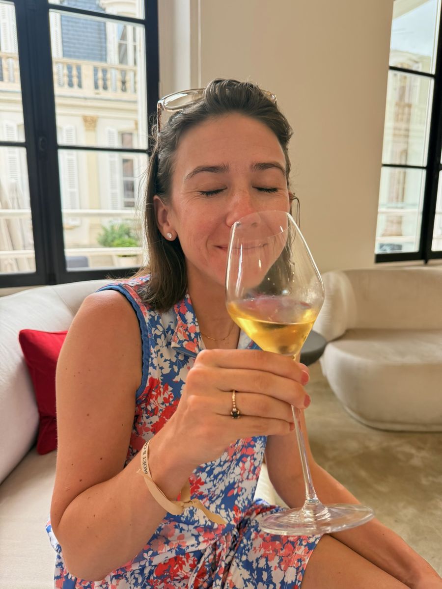 Haley, eyes closed, smelling a glass of white wine