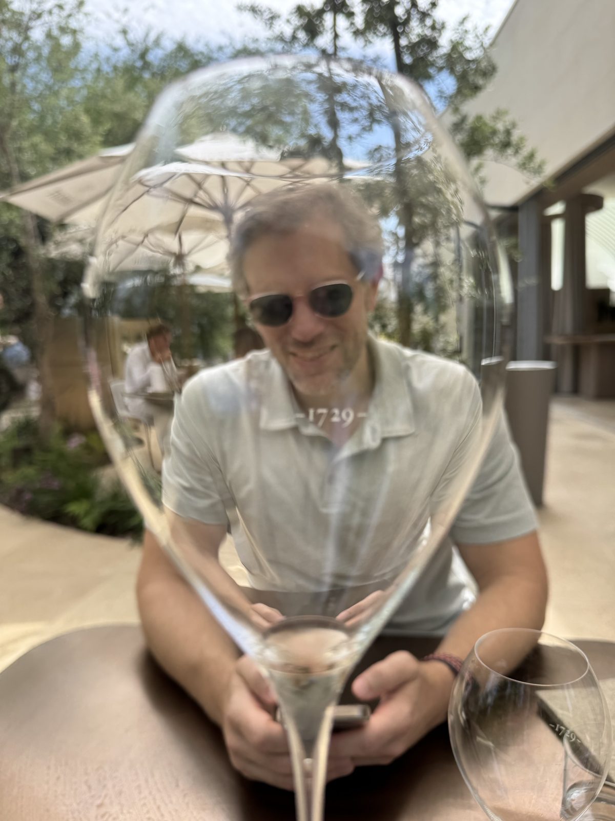 Michael on a garden terrace, seen through a large wine glass etched 1729